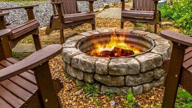A cabin with a stone fire pit, wooden deck, and Adirondack chairs. - Creekfront Views! Hot Tub/ 2 King Bed En Suites/Secluded/Arcade/Firepit/FastWifi (Pigeon Forge)