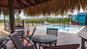 A poolside area with wooden deck, lounge chairs, and a pool. - Stone Fence (Sint Willibrordus)