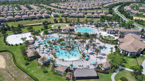 Relax by the central pool surrounded by lush landscaping and palm trees.