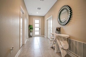 Stunning hallway with elegant mirror, comfortable seating area, and natural touches.