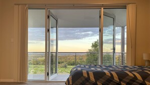 A bedroom with a large sliding glass door leading to a balcony with a view of the countryside. - Kesehills Wines Villa (Mount Pleasant)