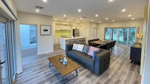 A modern living room with a sofa, coffee table, and dining area. - Kesehills Wines Villa (Mount Pleasant)