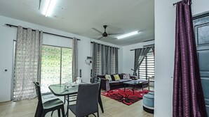 A modern living room with a dining area, a sofa set, and a ceiling fan. - OYO HOME 90682 Liliz Mambang Farmstay (Pekan)