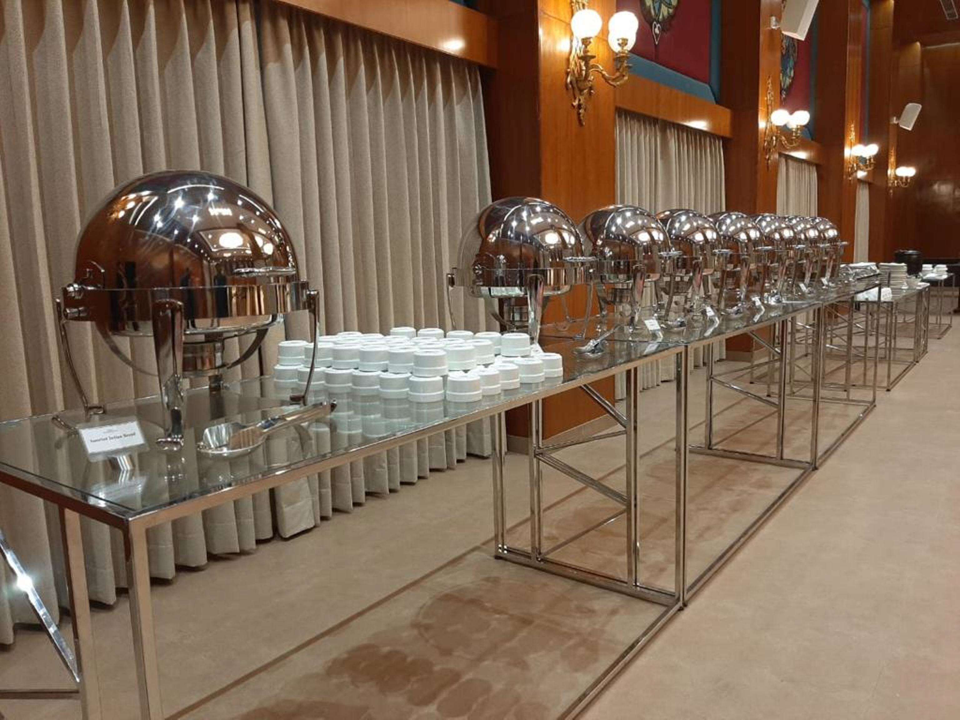 A buffet setup with multiple serving stations, each equipped with a large dome light and a glass display case.