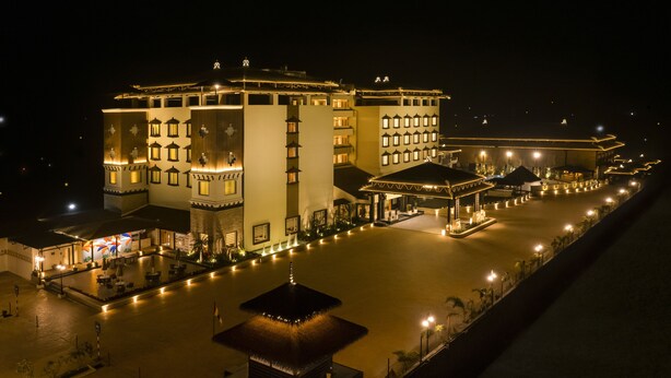 Un grand hôtel composé de plusieurs bâtiments, avec une cour centrale et un petit pavillon.