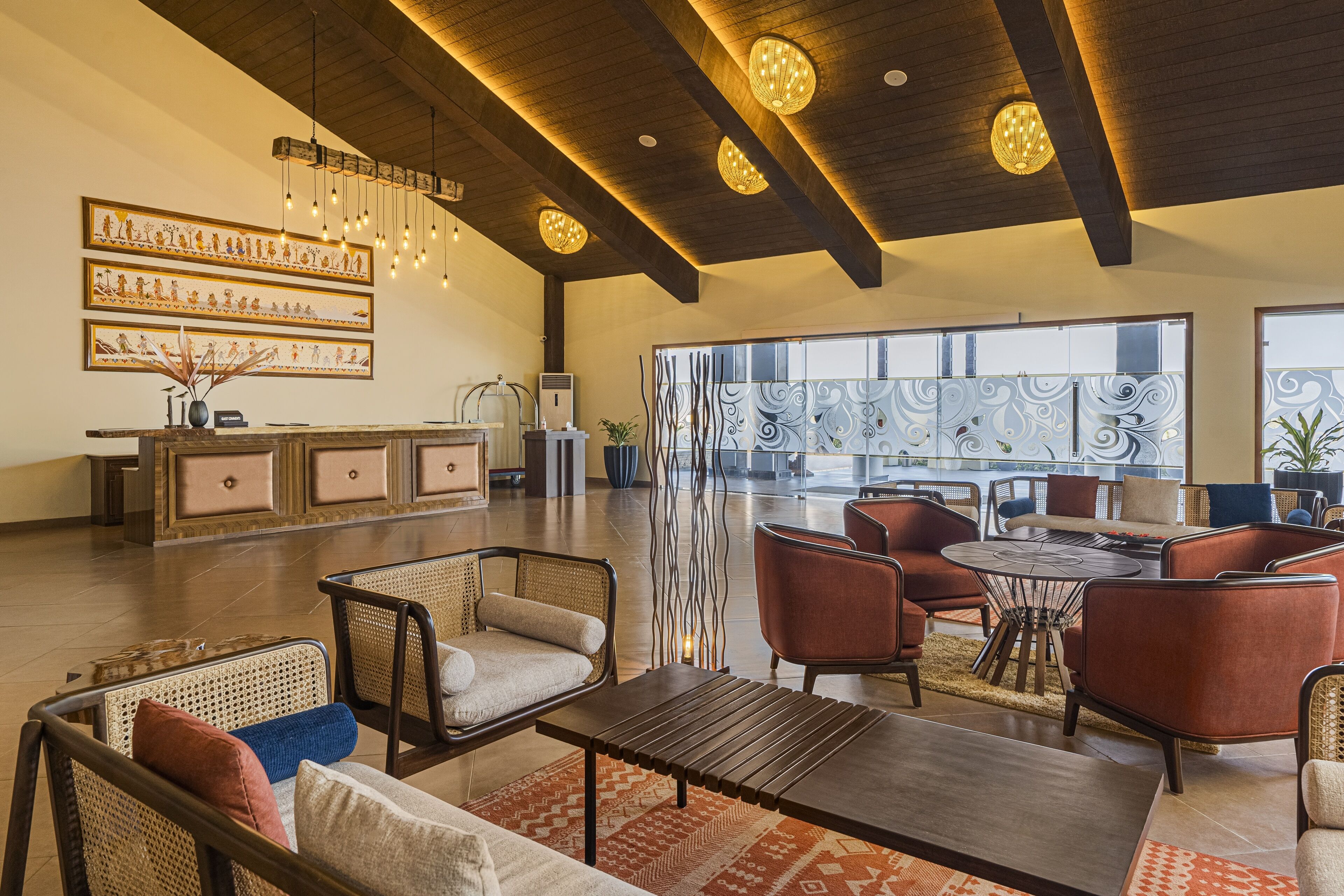 A spacious lobby with a high ceiling, modern furniture, and decorative wall art.