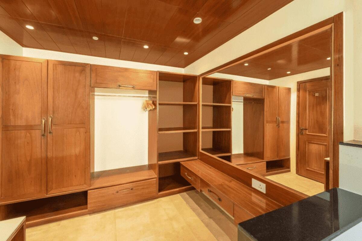 A spacious room with wooden cabinetry, built-in benches, and a black countertop.