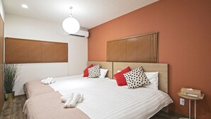 Een hotelkamer met een groot bed, twee nachtkastjes, een kamerplant en een houten vloer.