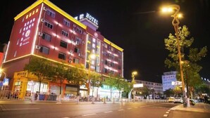 Et flere etagers hotel med et tydeligt 'HOTEL'-skilt på taget, flere etager og en velbelyst facade.
