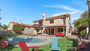 A backyard with a swimming pool, red and blue Adirondack chairs, a fire pit, and a patio area with outdoor furniture. - Southwestern Paradise, Simply Classic (Oro Valley)