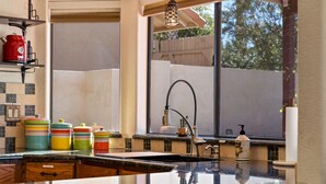 A kitchen with a large window, a sink, and colorful storage containers. - Southwestern Paradise, Simply Classic (Oro Valley)