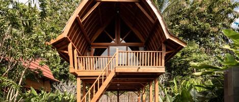Een houten chalet met een balkon en een zwembad.