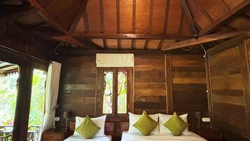 A wooden cabin with two beds, a window, and a ceiling light.