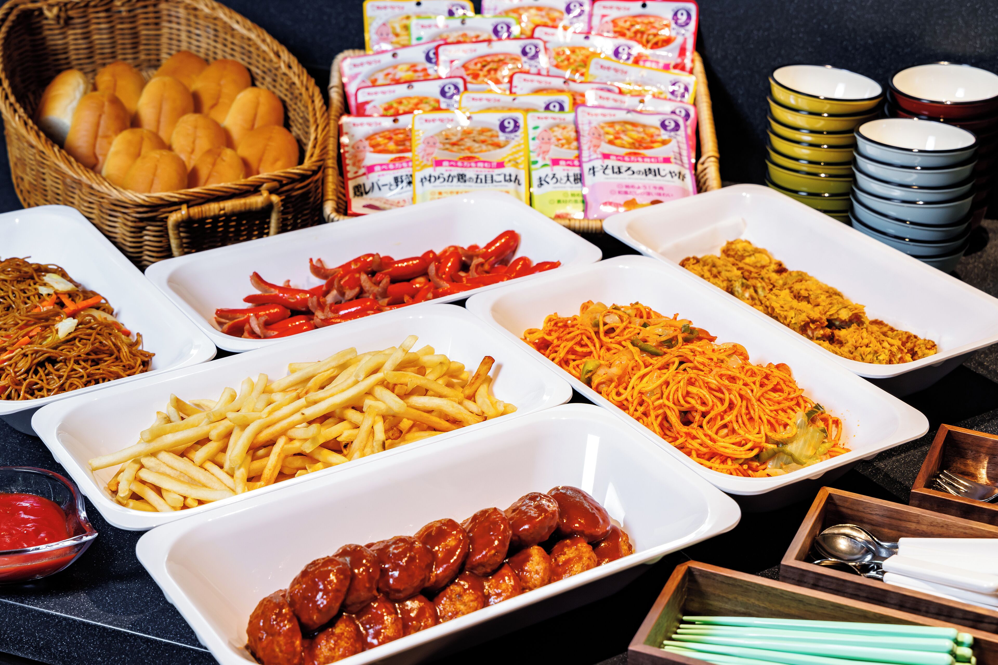 Een buffet met diverse gerechten, waaronder noedels, friet en vlees.