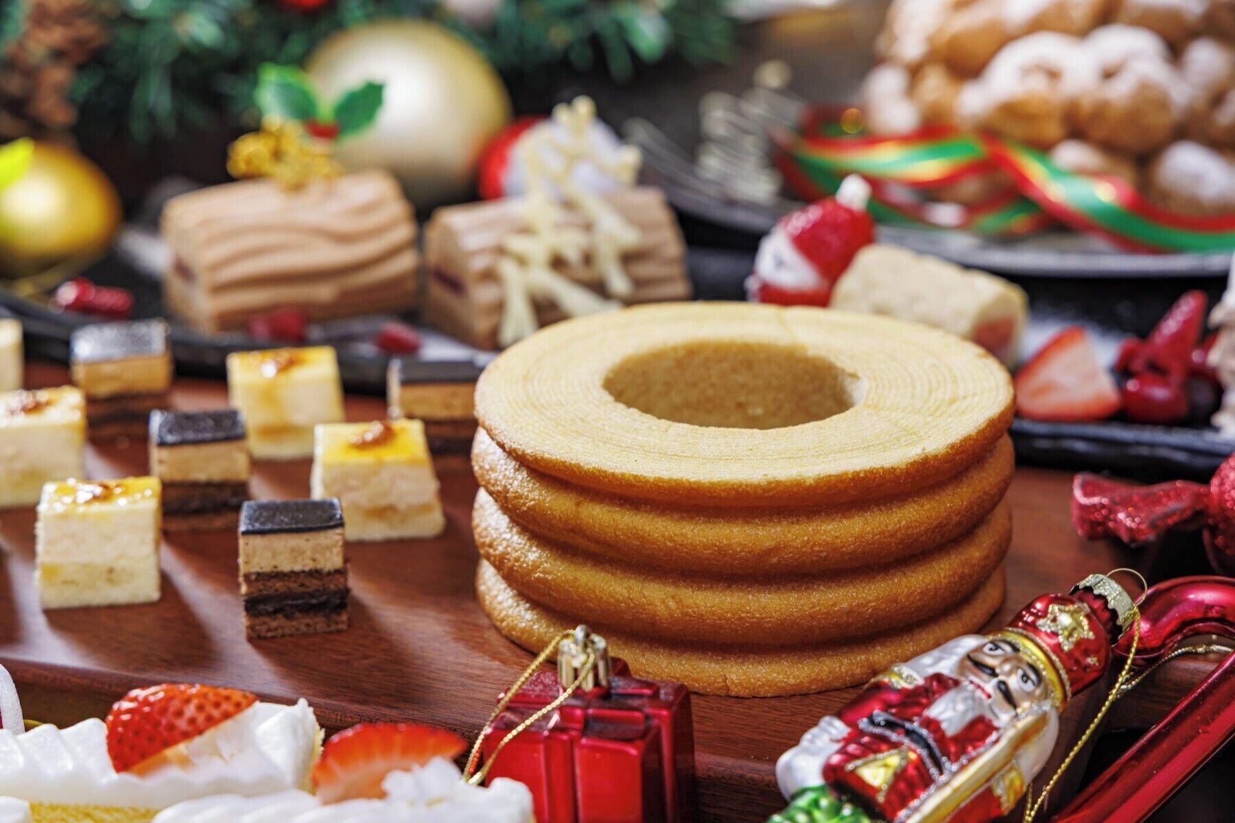 Un assortiment de desserts et de pâtisseries, notamment une pile de gâteaux à plusieurs couches et diverses confiseries.