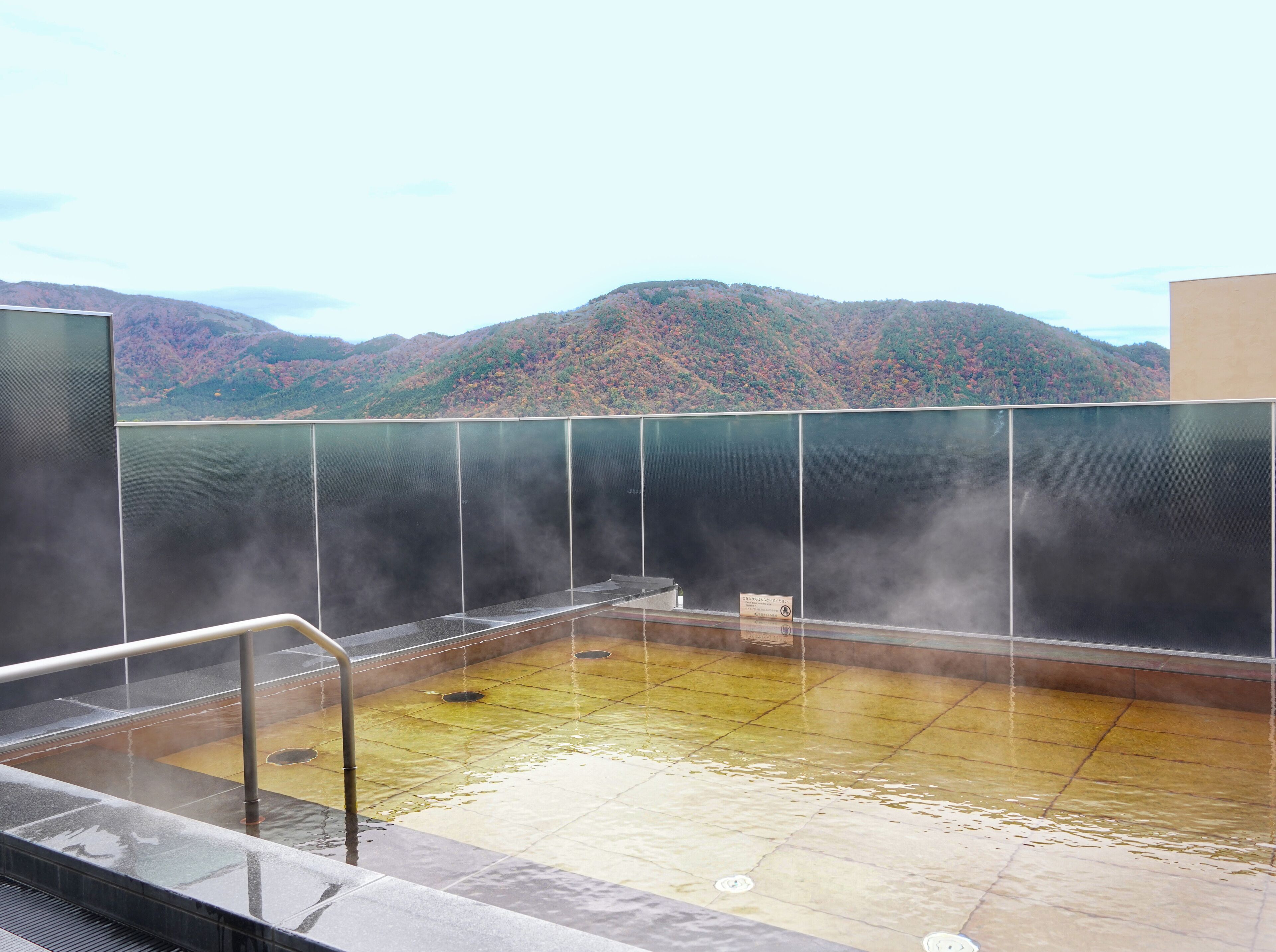 A hot spring bath with a view of mountains.