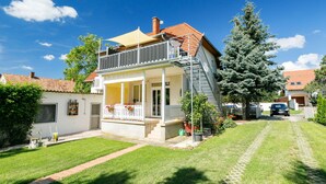 A two-story house with a balcony, a front porch, and a small garden. - Meretei Porta by Interhome (Balatonkeresztur)