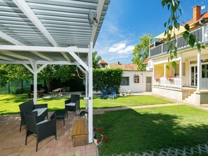 Relax in a serene outdoor space with a patio, wicker chairs, and a wooden table.