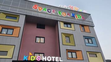 A multi-story building with colorful facades and signage for 'Space for Kids' and 'Kids Hotel'.
