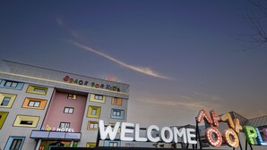 Un hôtel avec une signalétique colorée, notamment les inscriptions « ESPACE ENFANTS » et « BIENVENUE CHEZ VOUS ».