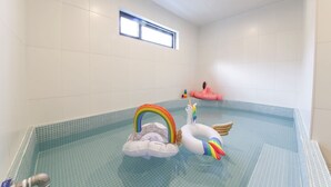 Une piscine avec un arc-en-ciel, un cygne et un flotteur en forme de licorne.
