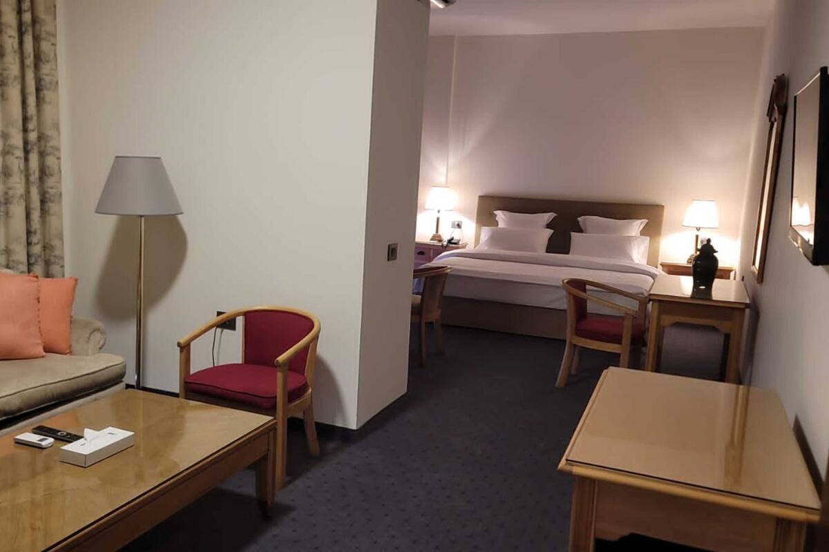 A hotel room with a sofa, a chair, a desk, and a bed.