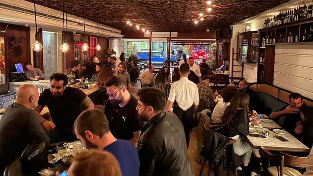 A busy restaurant with a unique ceiling design, patrons seated at tables, and a bar area visible in the background. - Hotel Napoleon Beirut (Beirut)