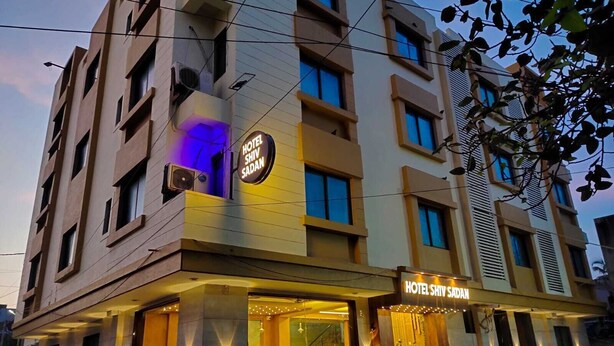 A hotel with a modern facade, multiple balconies, and a well-lit entrance. - Hotel Shiv Sasdan (Veraval)