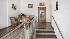 A staircase with a metal railing leading to a door with frosted glass panels.