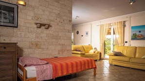 Ein Zimmer mit einem Bett und zwei gelben Sofas.