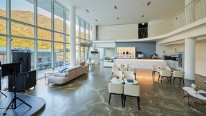 Un vestíbulo amplio con techo alto, ventanas grandes, zona de estar y área de cocina.