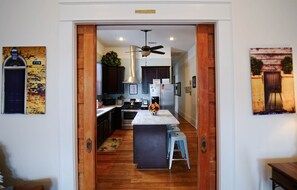 Uma cozinha moderna com piso de madeira, uma ilha central e armários escuros.