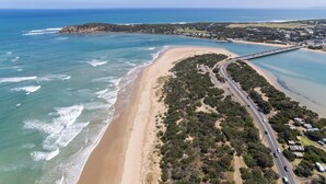 Vista aérea de una zona costera con playa, camino y puente.