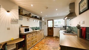 A kitchen with wooden cabinets, a microwave, and a sink.