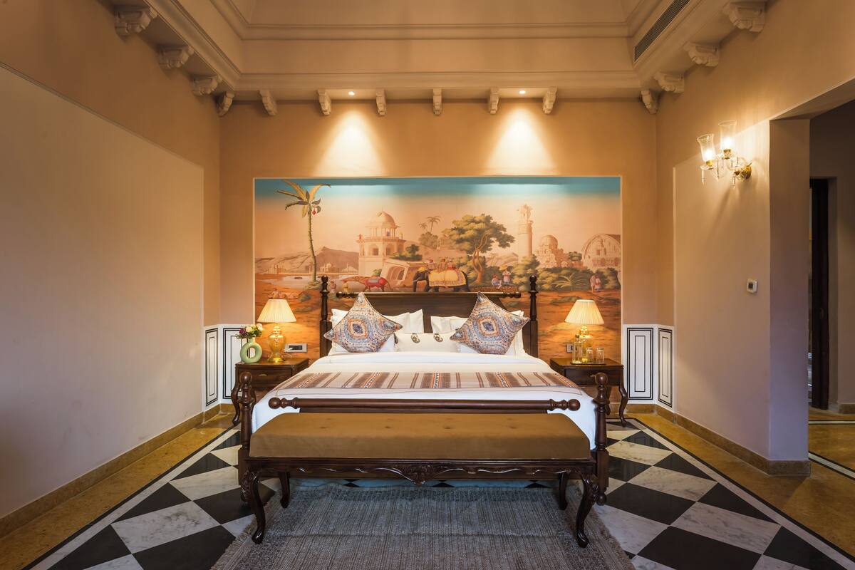 Una habitación de hotel con una cama grande, un mural en la pared y un suelo a cuadros.