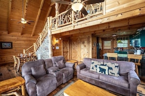 Relax in a spacious living area with a plush sofa and wooden dining table.