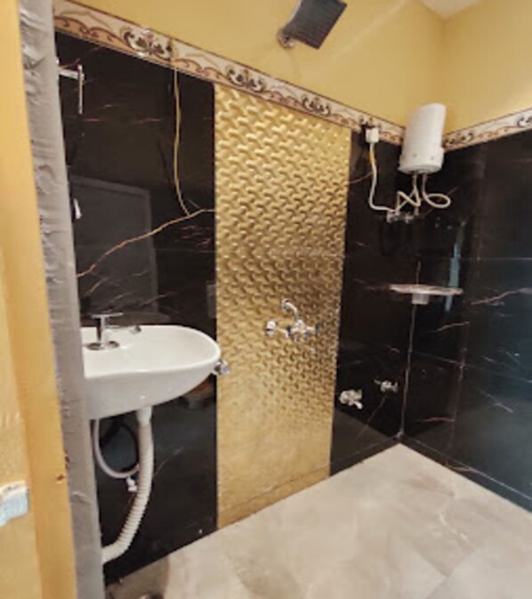 Ein Badezimmer mit Waschbecken, strukturierter Wand und Duschbereich.