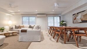Relax in this stylish living room with a comfortable sofa set, dining table, and large window.