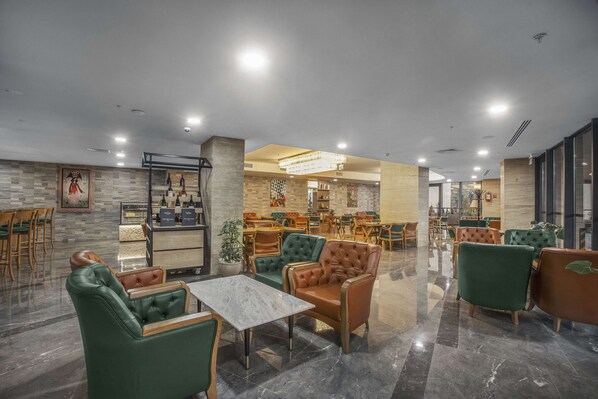 A spacious lobby with a variety of seating options, a reception area, and a bar. - Royal Tulip Hotel & Casino Tbilisi (Tbilisi)