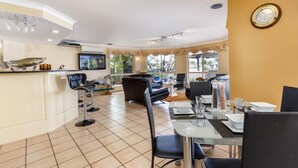 A modern dining area with a bar, seating, and a TV. - Paradise on Banksia Canal (BANKSIA BEACH)