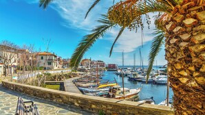 A marina with boats, a stone wall, and a bench. - Holiday home mit Klimaanlage (Stintino)