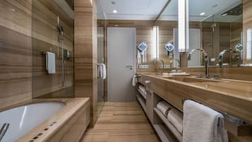 A modern bathroom with a large bathtub, a walk-in shower, and a vanity with a mirror.