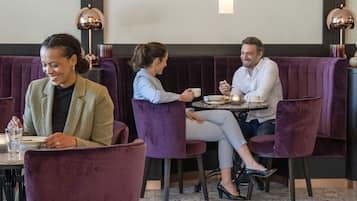 Un restaurante con cabinas de terciopelo morado y piso de mármol.