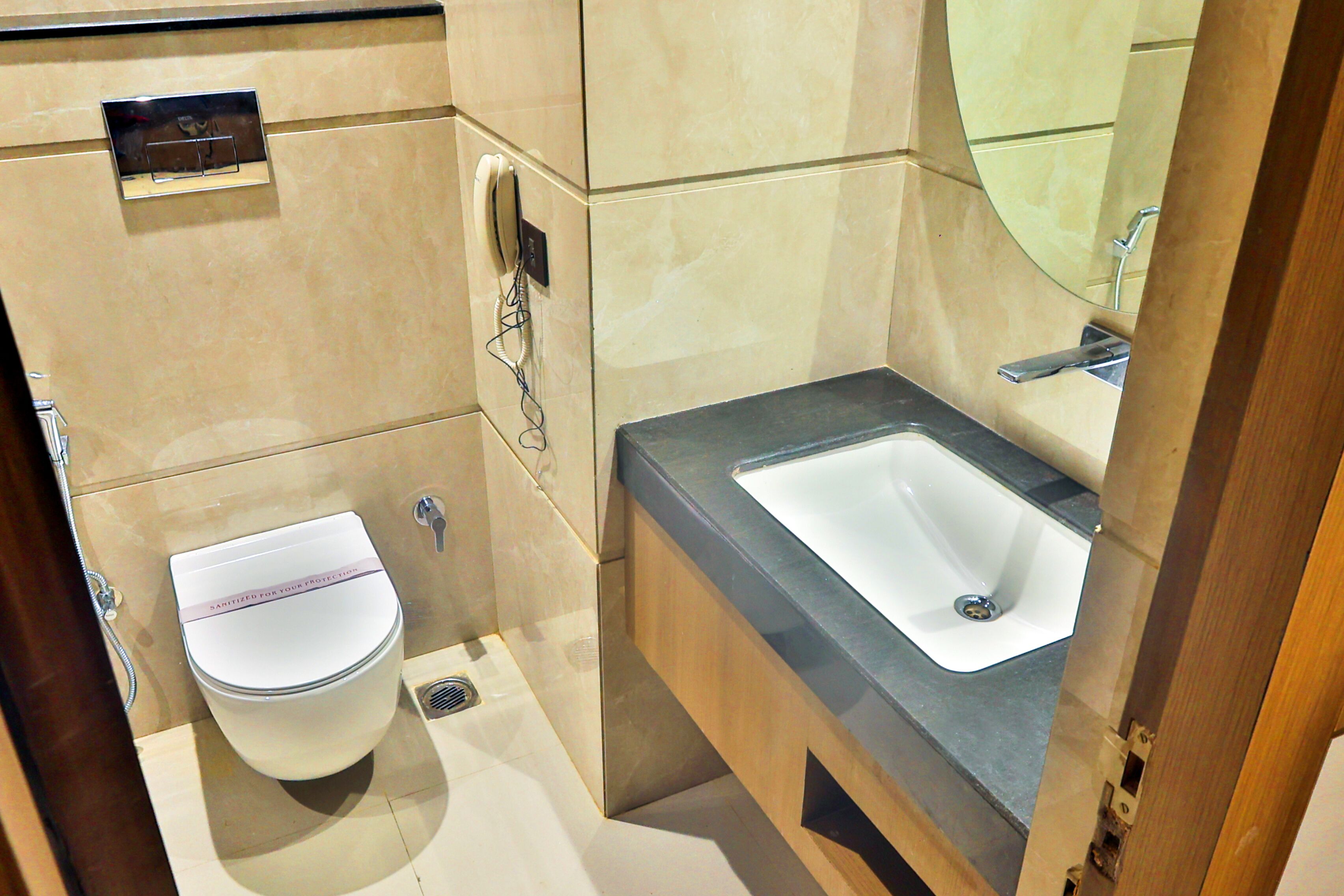 A modern bathroom with a toilet, sink, and mirror.