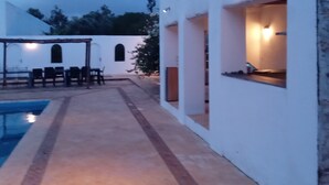 A pool area with a patio and outdoor seating.