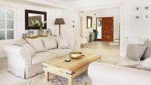 Een moderne woonkamer met een beige modulaire bank, een houten salontafel en een grote spiegel.