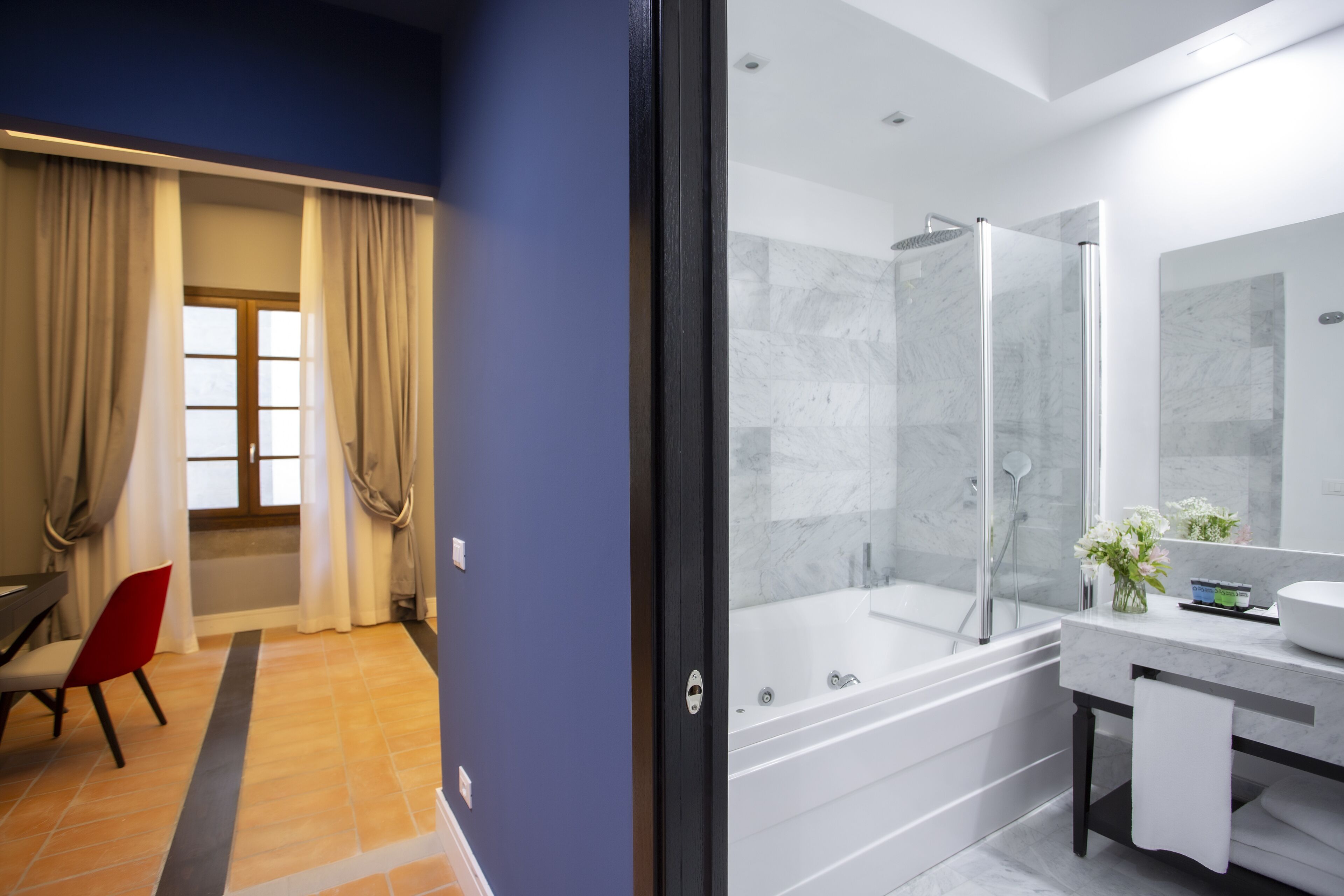 Un baño moderno con bañera, ducha y un espejo grande.