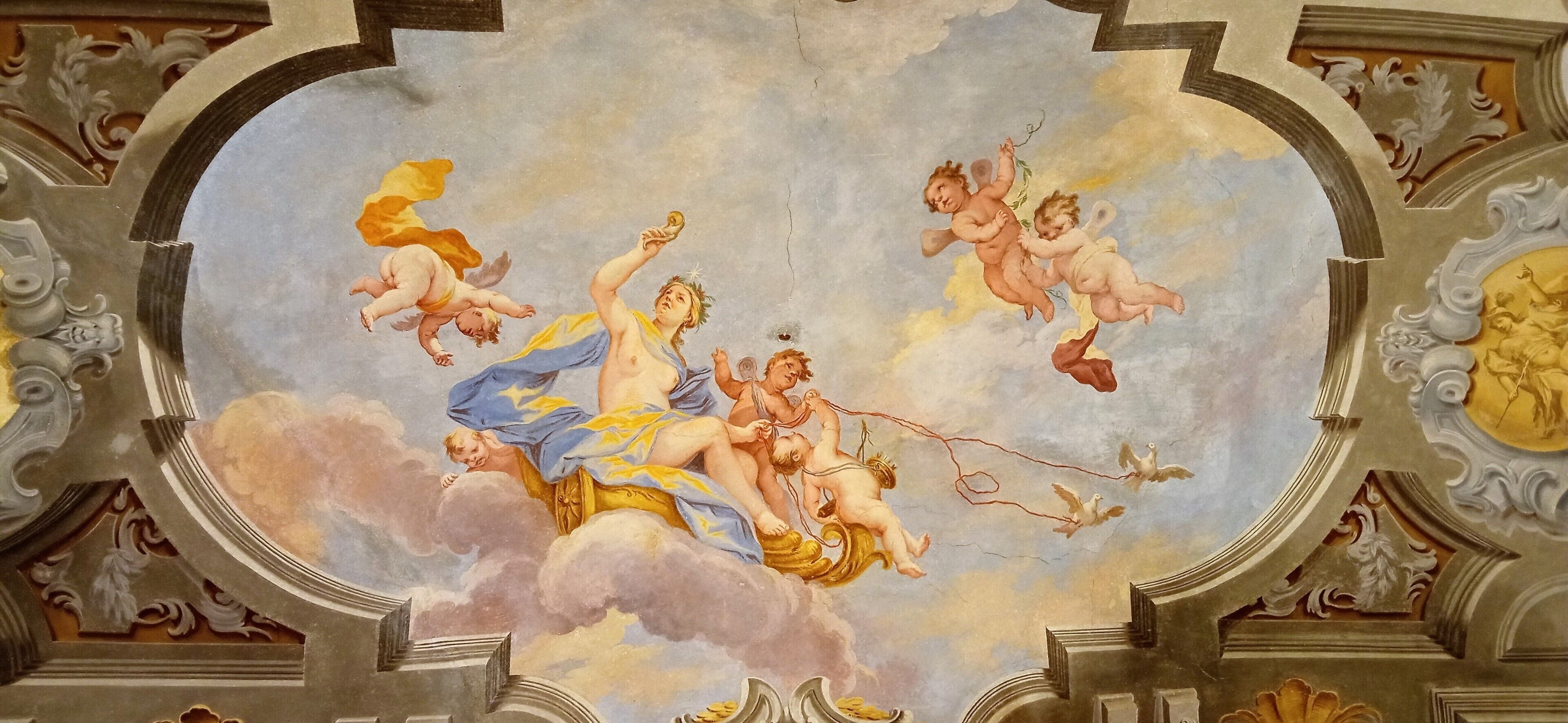 A ceiling fresco with cherubs and mythological figures.