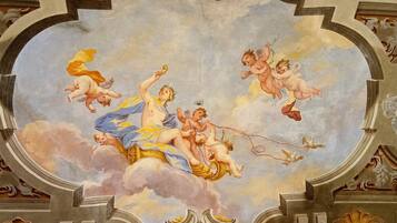A ceiling fresco with cherubs and mythological figures.
