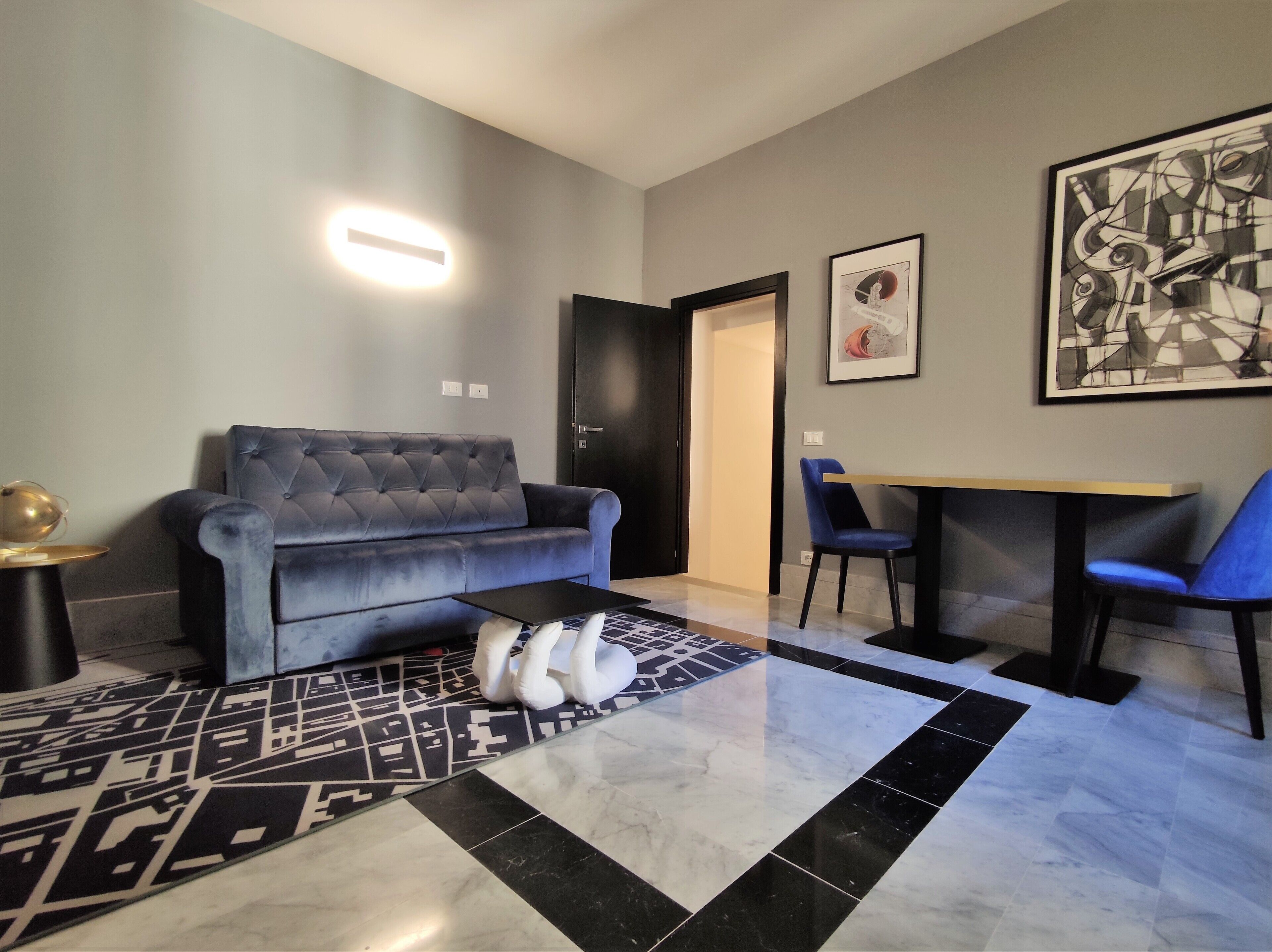 A modern living room with a grey sofa, a small table, and a patterned rug.
